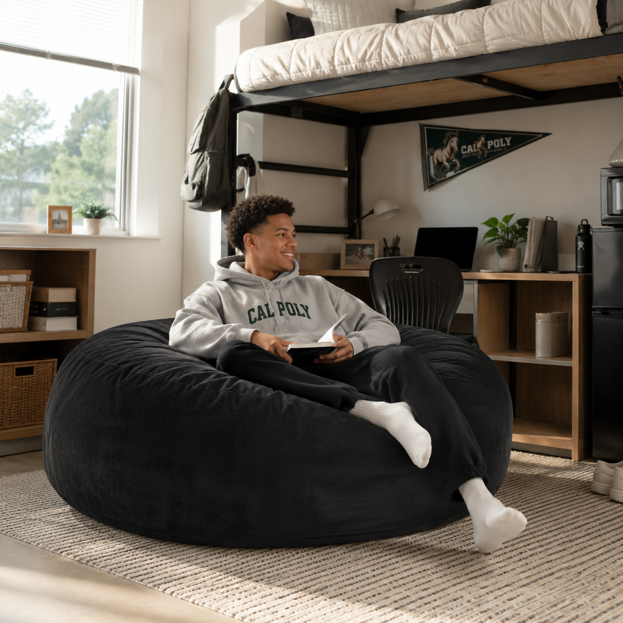 Pebble black bean bag chair showing a seated person gaming in a modern living room
