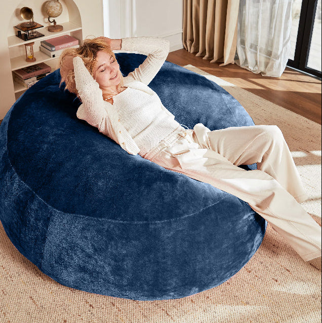 Pebble blue bean bag chair showing a woman reclining comfortably in a bright living room