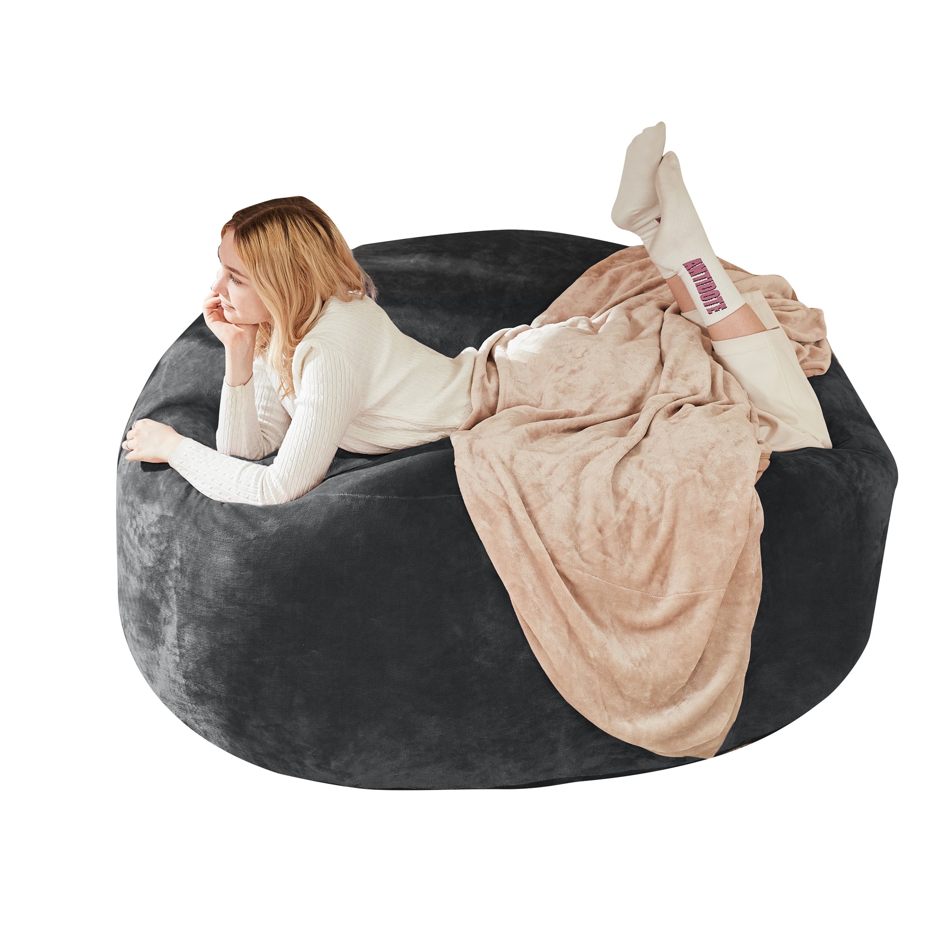 Pebble dark grey bean bag chair showing a seated woman reading against a white background