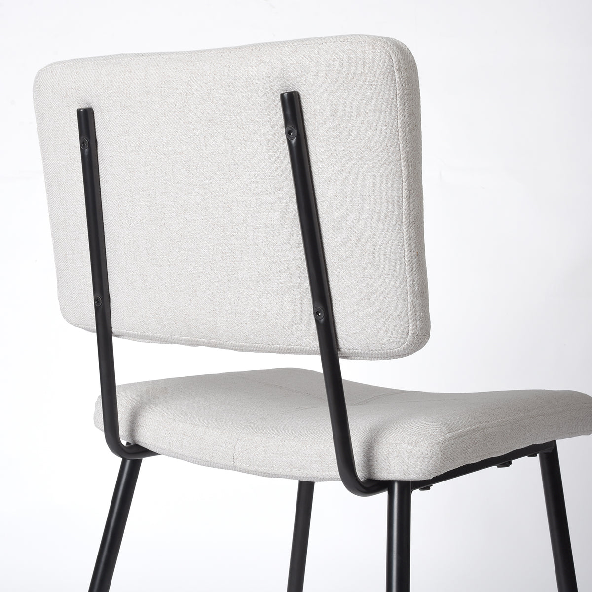 Pomona beige upholstered dining chair showing rear frame and backrest support detail
