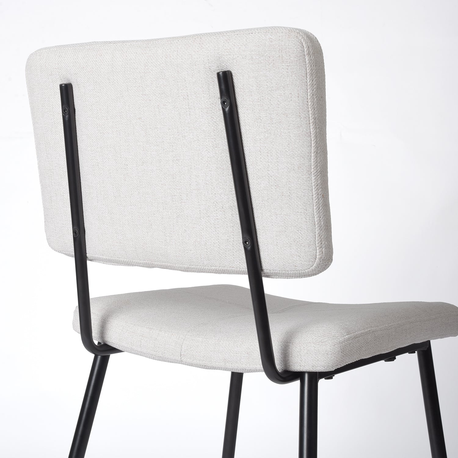 Pomona beige upholstered dining chair showing rear frame and backrest support detail