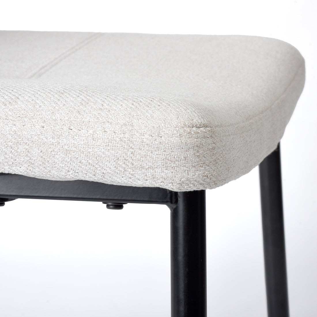 Pomona beige upholstered dining chair showing padded seat edge and metal leg detail