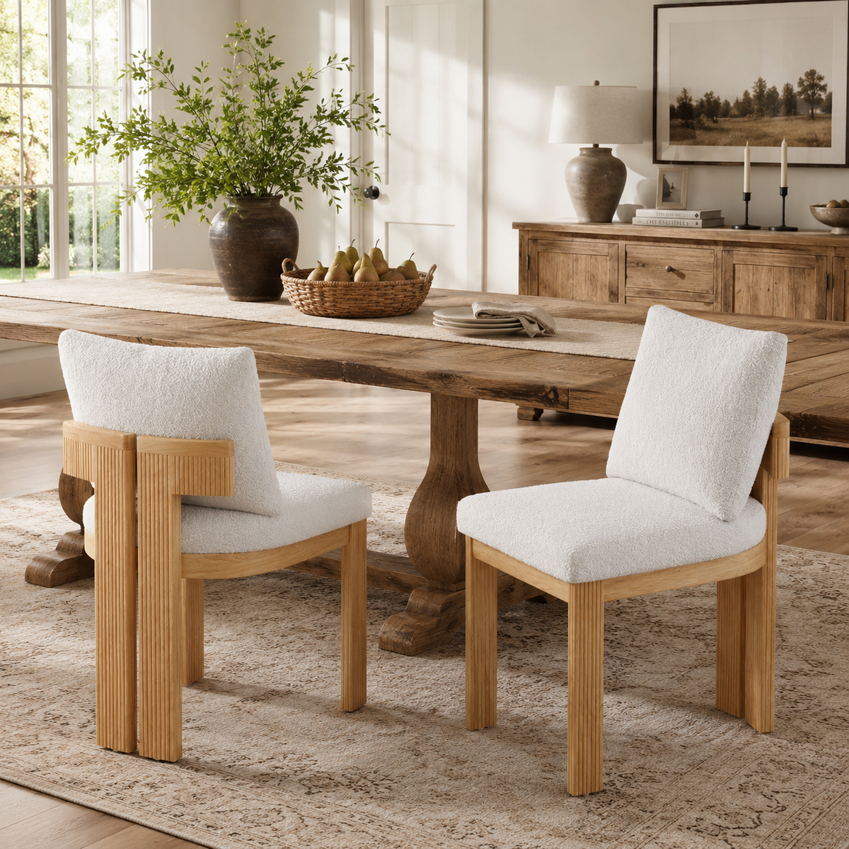 Pukaki white boucle dining chairs beside a wood table in a warm minimalist dining space