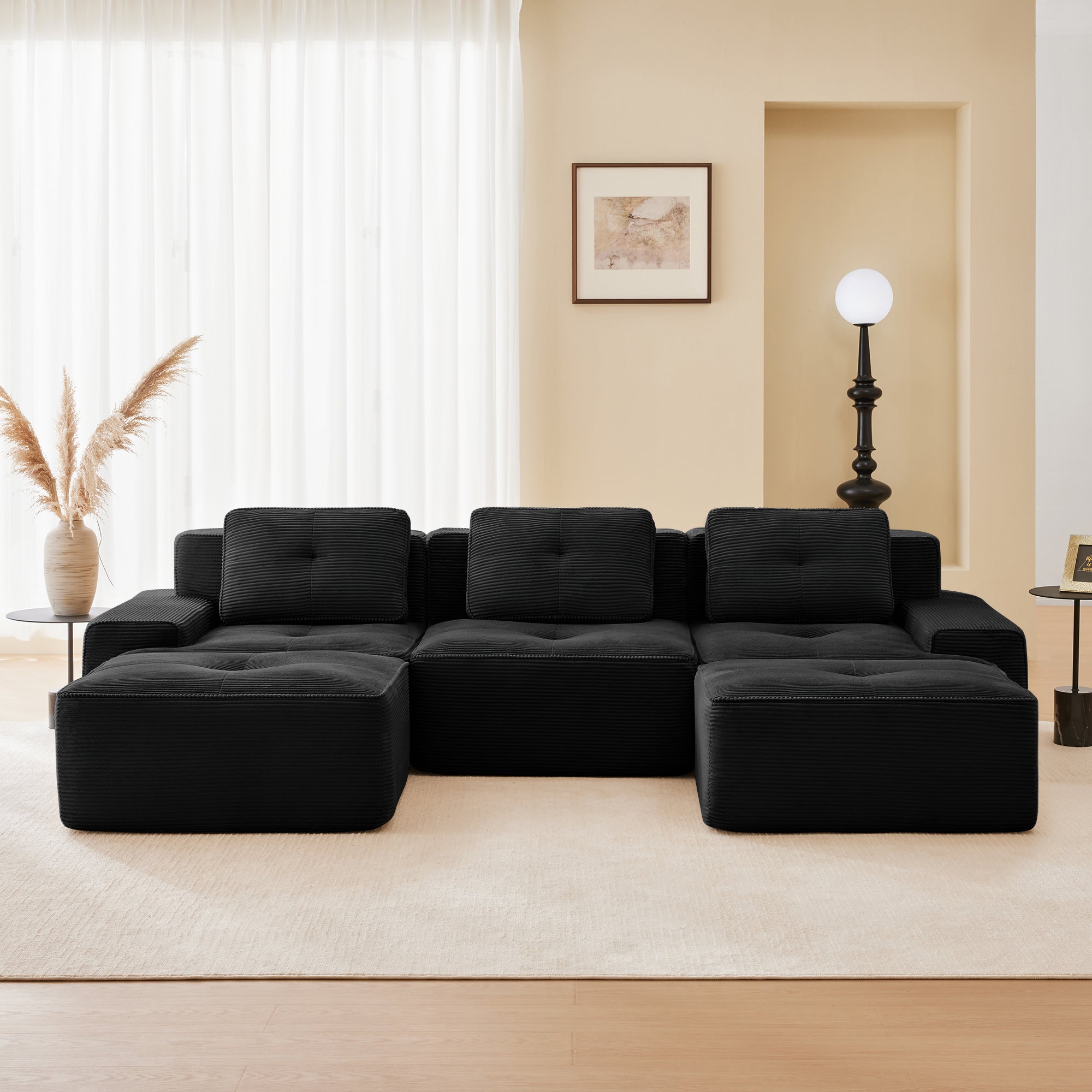 Racine black modular sofa showing front living room setup with dual ottomans