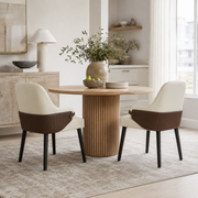 Saimaa brown two-tone upholstered dining chairs around a round wood table in a bright dining room
