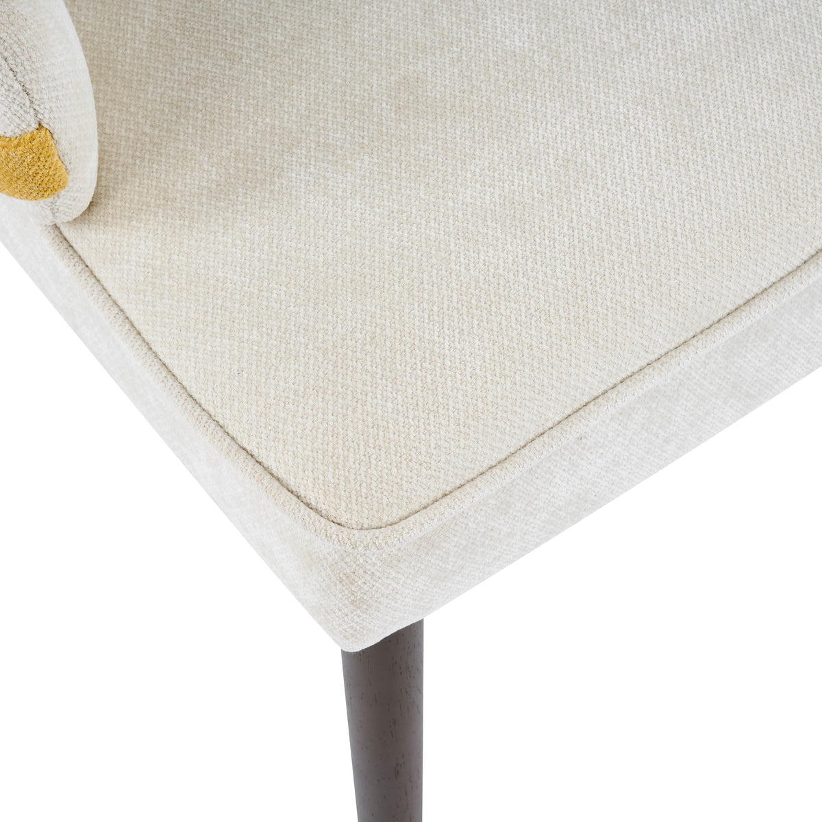 Saimaa yellow dining chair close-up of the upholstered seat edge and black tapered leg