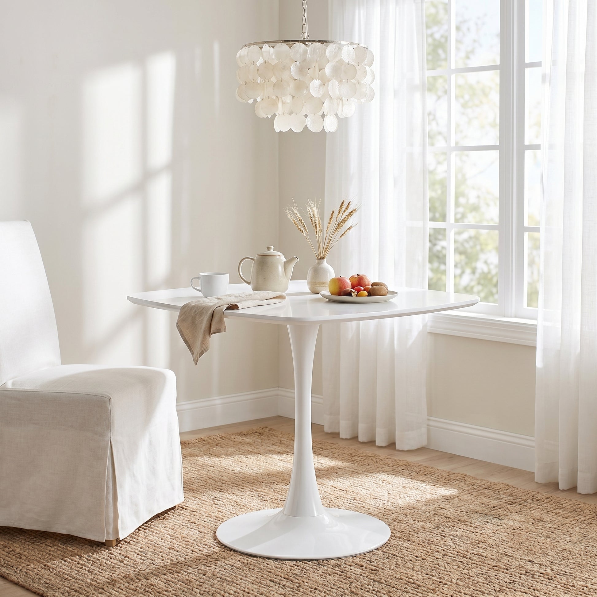 Santorini white dining table showing a sunlit dining area with floral centerpiece