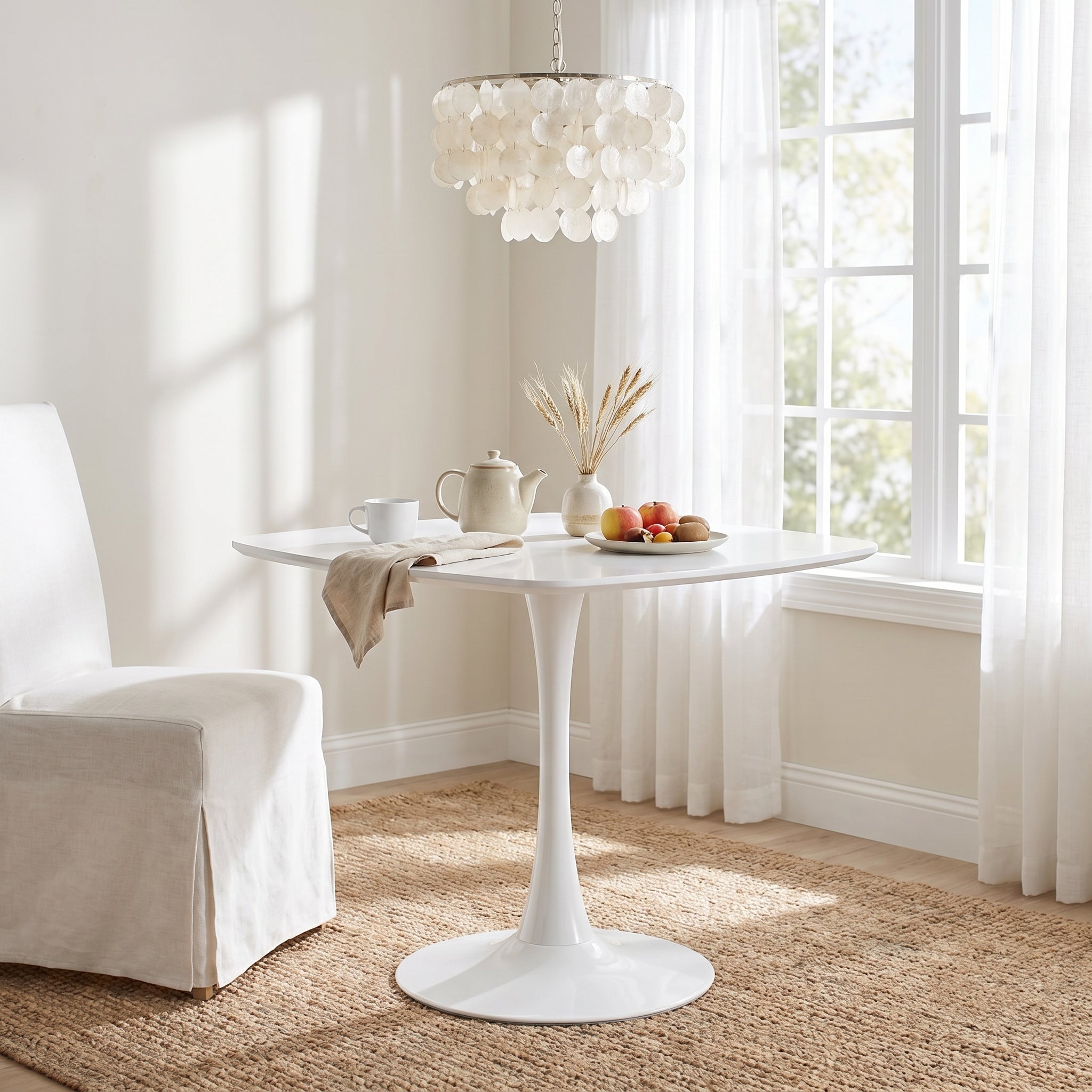 Santorini white dining table showing a sunlit dining area with floral centerpiece