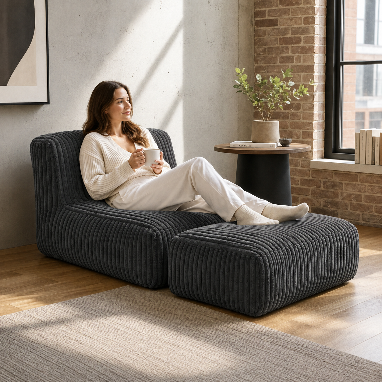 Stonebrook dark grey floor lounger chair showing person relaxing on chair in a living room