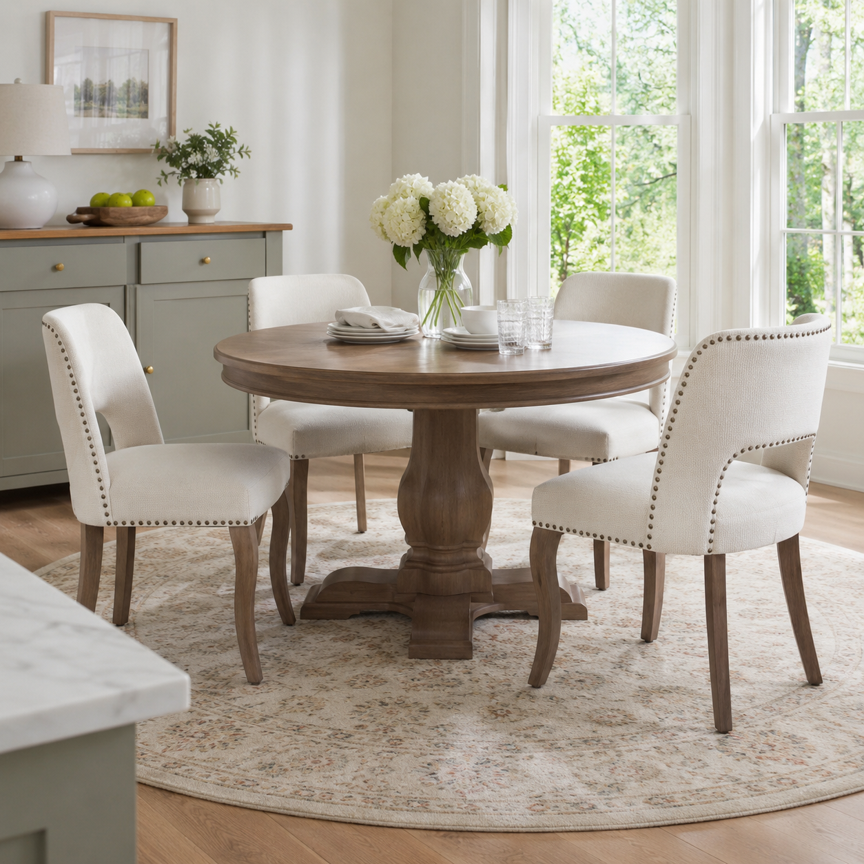 Tiberis beige dining chairs showing a pair around a round table in a bright dining room