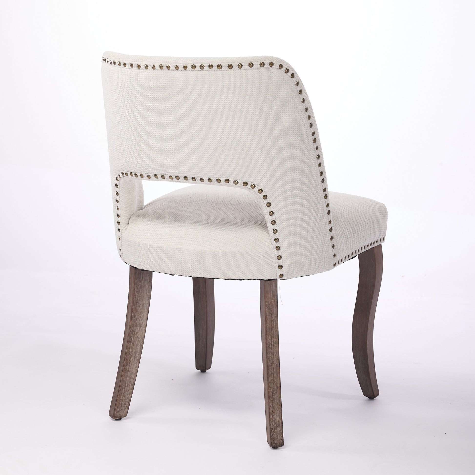 Tiberis beige dining chair showing a rear angled view of the open back and tapered legs
