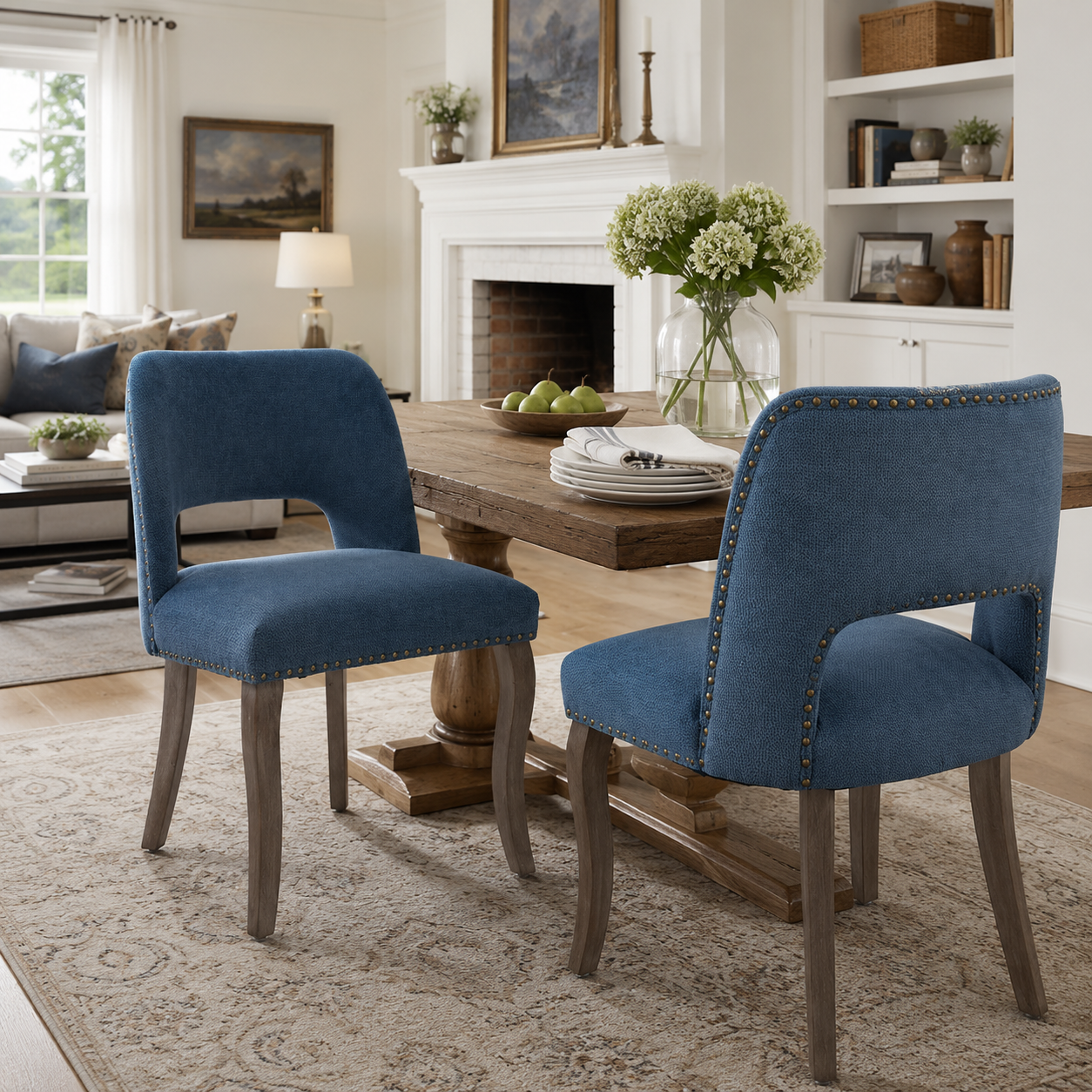 Tiberis blue dining chairs showing a pair beside a round table with a fireplace and shelving
