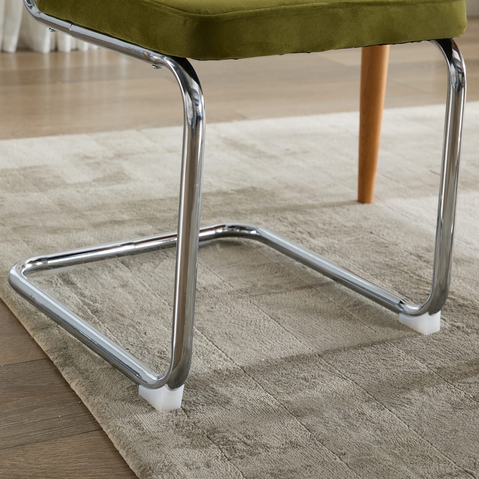 Tigris green dining chair close-up of the chrome cantilever base