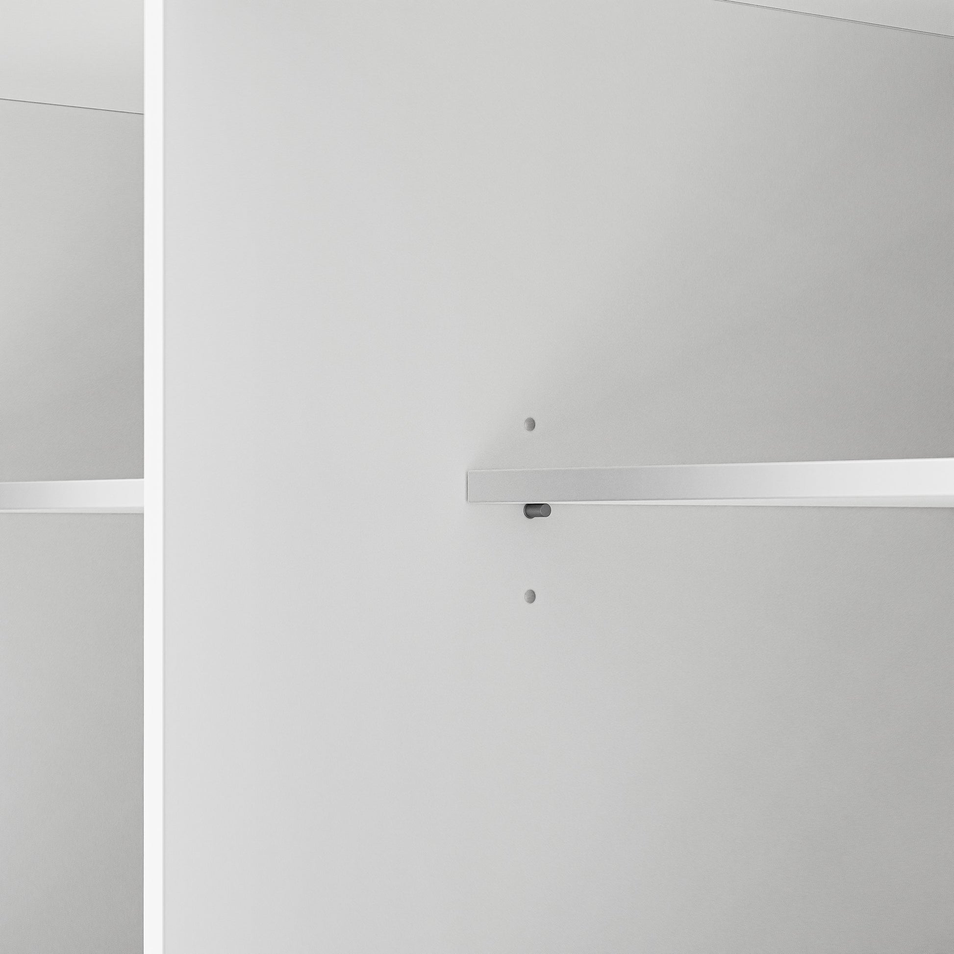 Close up of Toulouse white rolling kitchen island adjustable interior shelf support holes and cabinet storage detail