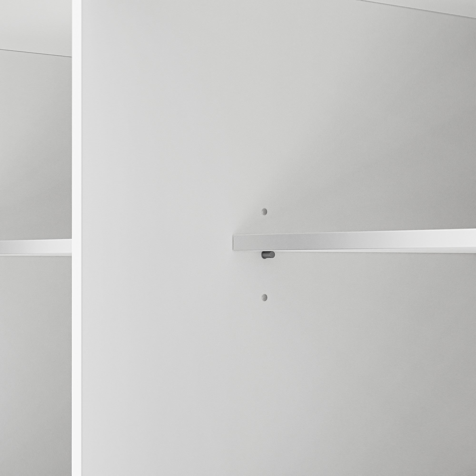 Close up of Toulouse white rolling kitchen island adjustable interior shelf support holes and cabinet storage detail
