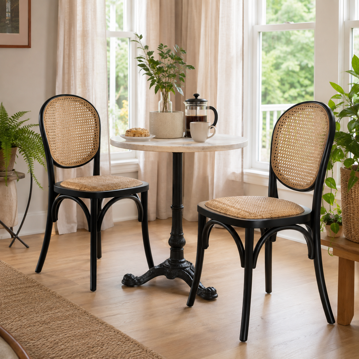 Vattern black cane dining chairs beside a round dining table in a sunlit dining space