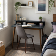 Visby grey writing desk showing an open hutch workspace with a chair beside a bright bedroom window