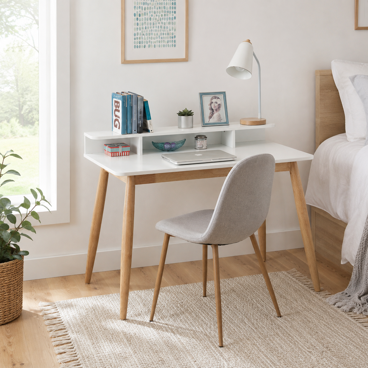 Visby white writing desk showing a small study setup with books and a chair beside a bed