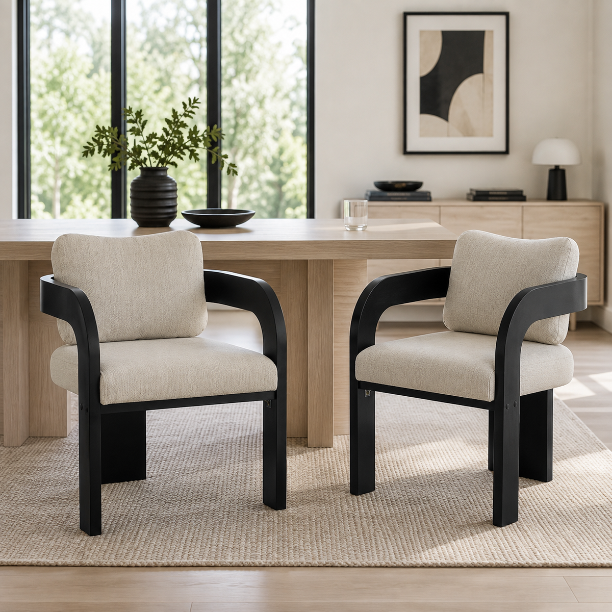 Wakatipu black dining armchairs in a sunlit dining room with a wood table and soft neutral styling