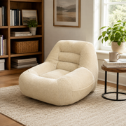 Westwood light camel bean bag armchair shown beside a bookcase and large window in a bright living room