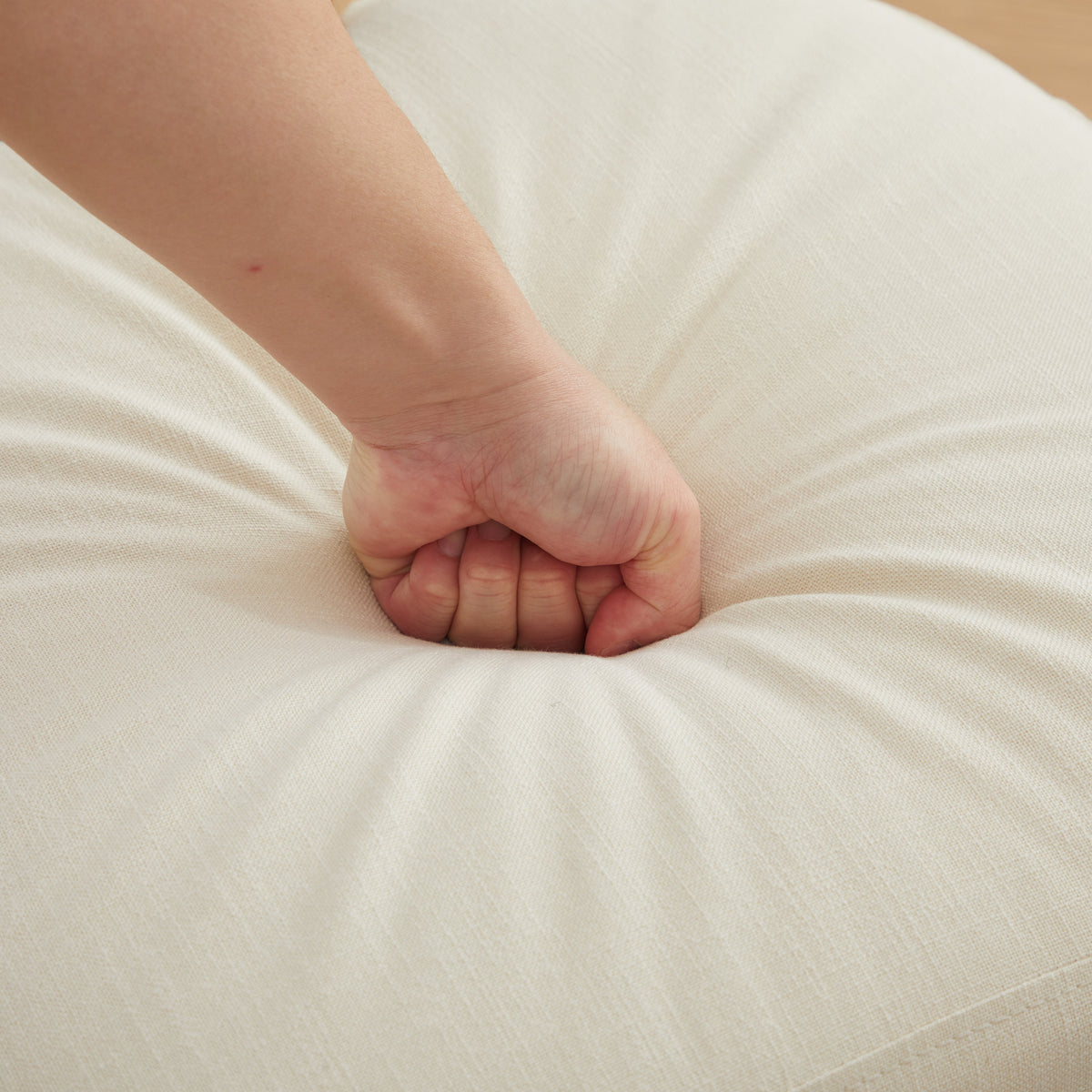 Yukon white dining chair close-up of the padded seat cushion with hand pressure